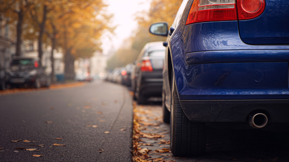 Zbliżenie na tył niebieskiego samochodu zaparkowanego przy drodze